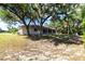 A sprawling backyard featuring mature trees and a screened-in lanai perfect for outdoor living at 14534 Keene Ave, Port Charlotte, FL 33953