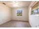 Bedroom with wood flooring, ceiling fan, and large windows overlooking the yard at 14534 Keene Ave, Port Charlotte, FL 33953