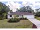 Charming front exterior featuring a manicured lawn, decorative bushes, and a two-car garage with ample parking at 14534 Keene Ave, Port Charlotte, FL 33953