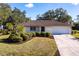 Charming single-story home featuring a well-manicured lawn, neat landscaping, and an attached two-car garage at 14534 Keene Ave, Port Charlotte, FL 33953