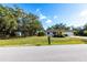 Well-maintained front yard with green grass, trimmed bushes, and a paved driveway leading to the garage at 14534 Keene Ave, Port Charlotte, FL 33953