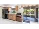 Kitchen with wooden cabinets, black appliances, and sliding glass door to screened patio at 14534 Keene Ave, Port Charlotte, FL 33953