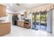 The kitchen features neutral tile flooring, light cabinetry, and sliding glass doors for plenty of natural light at 14534 Keene Ave, Port Charlotte, FL 33953