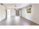 Spacious living room with wood-look floors, ceiling fan, and sliding glass door to outdoor patio at 14534 Keene Ave, Port Charlotte, FL 33953
