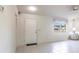Open living room, featuring white tile floors, a window, and natural light at 14534 Keene Ave, Port Charlotte, FL 33953