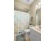 The bathroom features a shower with patterned curtain and a tiled floor at 1513 Urmey Ln, North Port, FL 34286