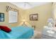 Cozy bedroom features a ceiling fan, framed art, and a bright blue quilt at 1513 Urmey Ln, North Port, FL 34286
