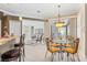 Dining area adjacent to the kitchen and living room, featuring a glass table and bright chandelier at 1513 Urmey Ln, North Port, FL 34286