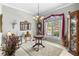 Elegant dining room with decorative chandelier, large window, and view of the front yard at 1513 Urmey Ln, North Port, FL 34286