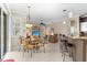 Open dining area with modern lighting, dining table, and seamless flow into the living spaces at 1513 Urmey Ln, North Port, FL 34286