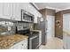Modern kitchen featuring stainless steel appliances, granite countertops, and stylish white cabinetry at 1513 Urmey Ln, North Port, FL 34286