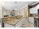 Kitchen with granite countertops, stainless steel appliances, and open view to the living area at 1513 Urmey Ln, North Port, FL 34286