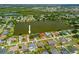Aerial view of a waterfront property featuring a private lake, mature trees, and established neighborhood at 158 Norman St, Port Charlotte, FL 33954