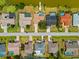 Birds-eye view of a neighborhood featuring homes with pools, manicured lawns, and a serene lake backdrop at 158 Norman St, Port Charlotte, FL 33954