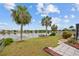 Scenic backyard with lush grass, a small dock, and tranquil lake views offering a peaceful retreat at 158 Norman St, Port Charlotte, FL 33954