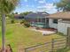 Spacious backyard showcases a screened-in pool and lush landscaping offering privacy and tranquility at 158 Norman St, Port Charlotte, FL 33954