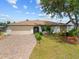 Charming single-story home boasts a brick driveway, two-car garage, and mature landscaping at 158 Norman St, Port Charlotte, FL 33954