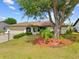 Well-maintained single-story home featuring a spacious front yard with lush landscaping and a mature shade tree at 158 Norman St, Port Charlotte, FL 33954