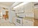 White kitchen featuring an oven, microwave, refrigerator, and granite counters at 158 Norman St, Port Charlotte, FL 33954