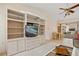 Living room featuring built-in shelving, media center, and view of the lanai and pool at 158 Norman St, Port Charlotte, FL 33954