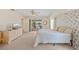 Bright main bedroom with lake views, sliding doors, ceiling fan, floral wallpaper, and comfortable furnishings at 158 Norman St, Port Charlotte, FL 33954