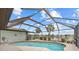 Screened-in pool overlooking a serene lake view, perfect for relaxation and enjoying the outdoors at 158 Norman St, Port Charlotte, FL 33954