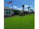 Well-manicured backyard featuring lush green lawn and meticulous landscaping and view of neighbors at 16909 Caracara Pl, Punta Gorda, FL 33982