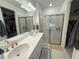 Bright bathroom featuring a double sink vanity, walk-in shower, and access to dual walk-in closets at 16909 Caracara Pl, Punta Gorda, FL 33982
