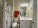 This bathroom features a single sink vanity and shower/tub with a patterned shower curtain at 16909 Caracara Pl, Punta Gorda, FL 33982