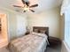 Comfortable bedroom featuring neutral walls, a ceiling fan, and a bed with decorative pillows at 16909 Caracara Pl, Punta Gorda, FL 33982