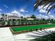 Bocce ball court adjacent to the community pool, surrounded by palm trees and greenery at 16909 Caracara Pl, Punta Gorda, FL 33982