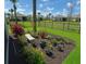 Landscaped garden adorned with colorful flowers, potted plants, and a charming stone bench at 16909 Caracara Pl, Punta Gorda, FL 33982