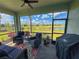 Screened lanai with comfortable outdoor seating overlooking a pond and neighborhood at 16909 Caracara Pl, Punta Gorda, FL 33982