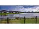 Beautiful lake view with a black fence and row of houses in the background at 16909 Caracara Pl, Punta Gorda, FL 33982