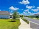 Street view featuring well-manicured lawns, sidewalks, and tidy landscaping in the community at 16909 Caracara Pl, Punta Gorda, FL 33982