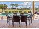 Screened-in lanai with a dining table and a view of the pool and golf course at 2117 Deborah Dr, Punta Gorda, FL 33950