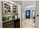 Inviting hallway features a built-in bar area, a striking blue front door, and decorative tile flooring at 22498 Westchester Blvd, Punta Gorda, FL 33980