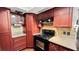 Functional kitchen with a black stove, dark wood cabinets, and neutral countertops at 22498 Westchester Blvd, Punta Gorda, FL 33980