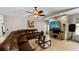Cozy living room featuring a large sectional sofa, a ceiling fan, and a decorative stone wall with a flatscreen TV at 22498 Westchester Blvd, Punta Gorda, FL 33980