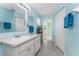 A full bathroom in blue with a single sink vanity, closet, and a doorway to another room at 25046 Doredo Dr, Punta Gorda, FL 33955