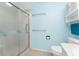 A fully renovated light blue bathroom with a shower and a toilet at 25046 Doredo Dr, Punta Gorda, FL 33955