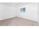 An empty bedroom with a ceiling fan, carpet, and one window at 25046 Doredo Dr, Punta Gorda, FL 33955