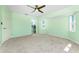 A carpeted bedroom with a ceiling fan and a doorway to another room at 25046 Doredo Dr, Punta Gorda, FL 33955