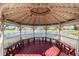 View from inside the gazebo overlooking a serene pond with a fountain and park-like grounds at 25046 Doredo Dr, Punta Gorda, FL 33955