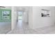 Bright hallway featuring tile flooring leading to various rooms, and view of the backyard at 25046 Doredo Dr, Punta Gorda, FL 33955