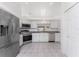 Spacious kitchen featuring stainless steel appliances, granite countertops, and neutral tile flooring at 25046 Doredo Dr, Punta Gorda, FL 33955