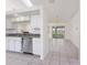 Open kitchen layout showcasing a stainless steel dishwasher, granite countertops and neutral tile flooring at 25046 Doredo Dr, Punta Gorda, FL 33955