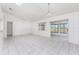 Bright living room featuring tiled floors, modern ceiling fan, and sliding glass doors to the backyard at 25046 Doredo Dr, Punta Gorda, FL 33955