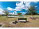 Scenic pond view with a fountain and park bench, framed by lush green space under a sunny sky at 25046 Doredo Dr, Punta Gorda, FL 33955