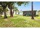 Expansive backyard showcases mature trees and a screened patio for outdoor relaxation at 25324 Aysen Dr, Punta Gorda, FL 33983
